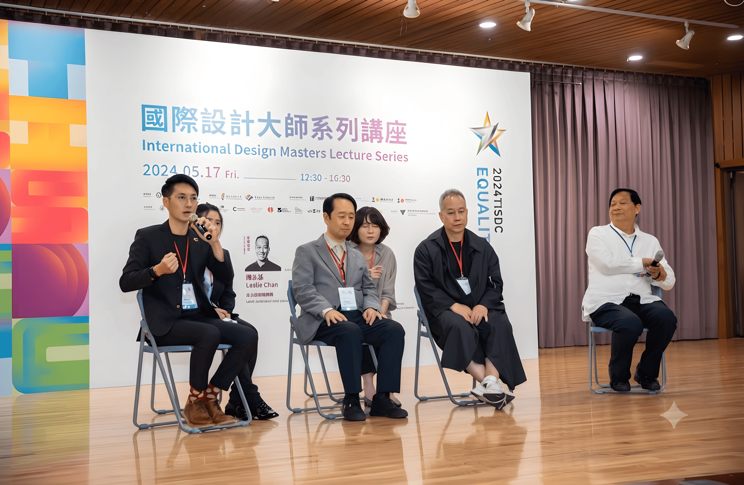 Panelists sitting on chairs on a stage during the International Design Masters Lecture Series event.
