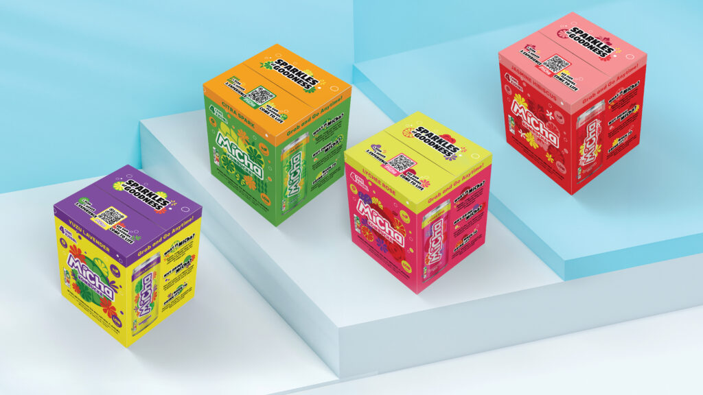 Colorful packaged four-pack boxes for Micha drinks displayed on light blue steps.